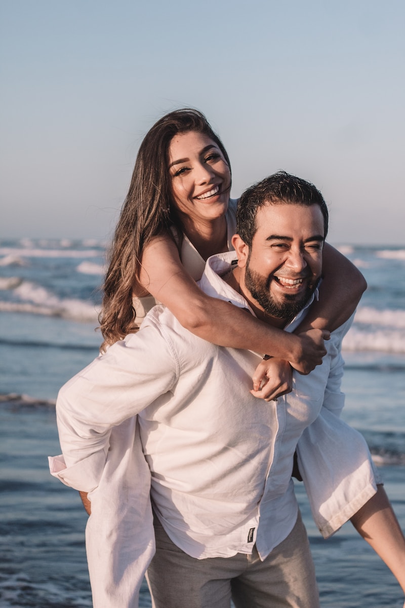 man in white dress shirt hugging woman in white dress