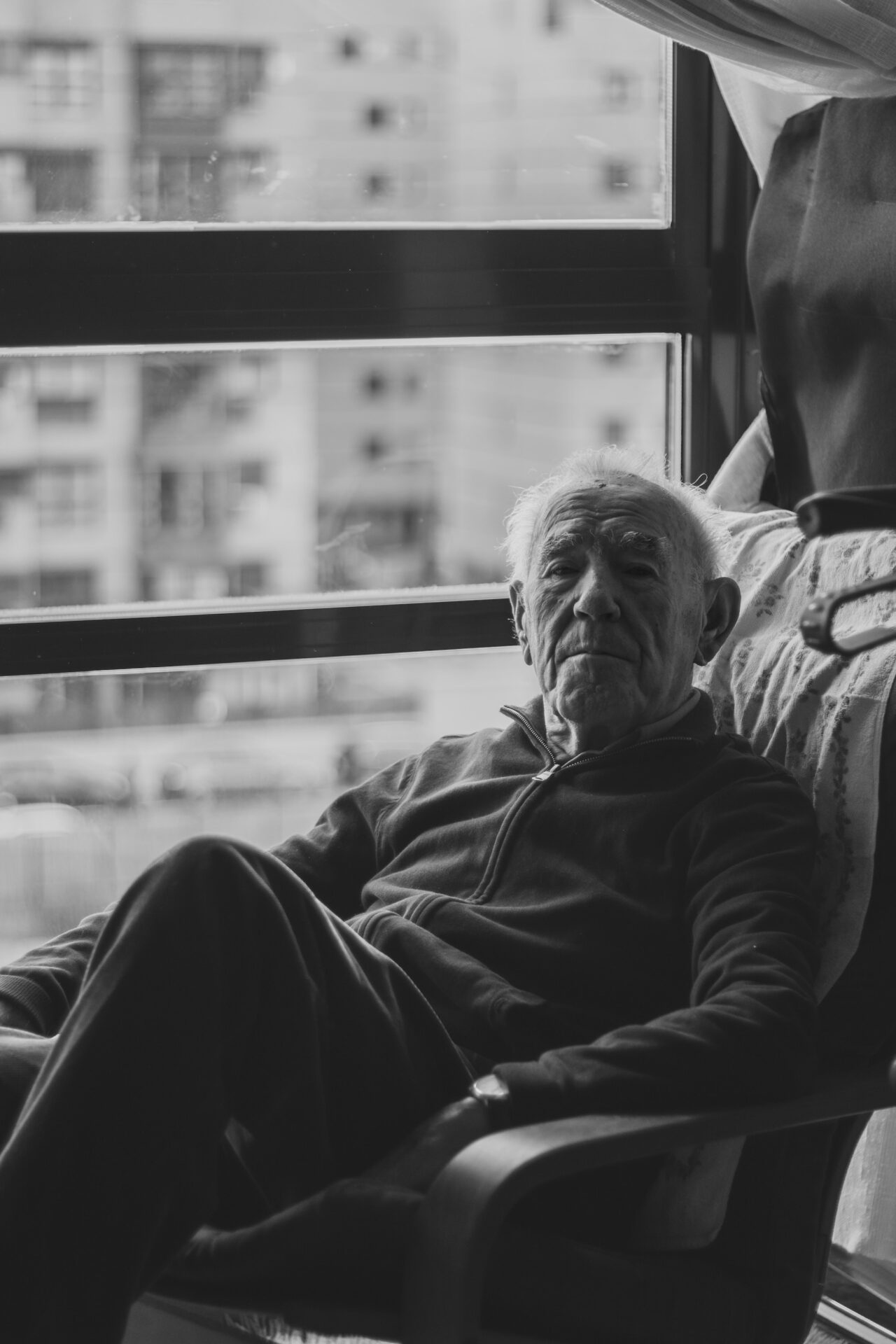 a man sitting in a chair looking out a window
