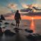 man standing on stone looking at sunset